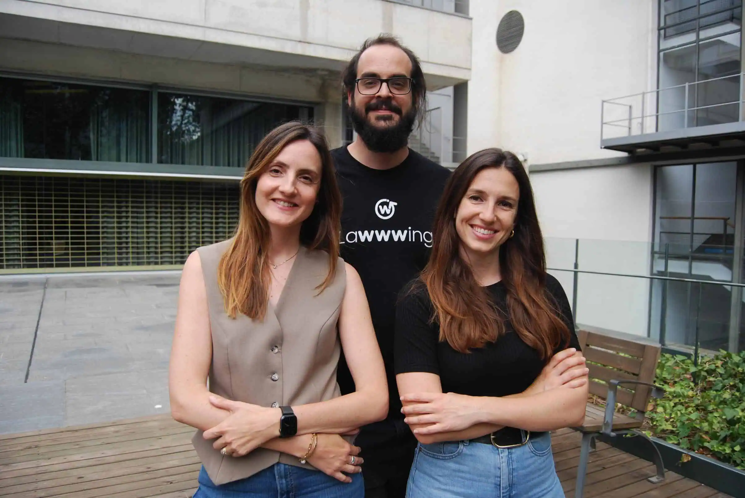 Team members of Lawwwing smiling and posing outdoors in a professional setting. One of them is wearing a Lawwwing-branded t-shirt.